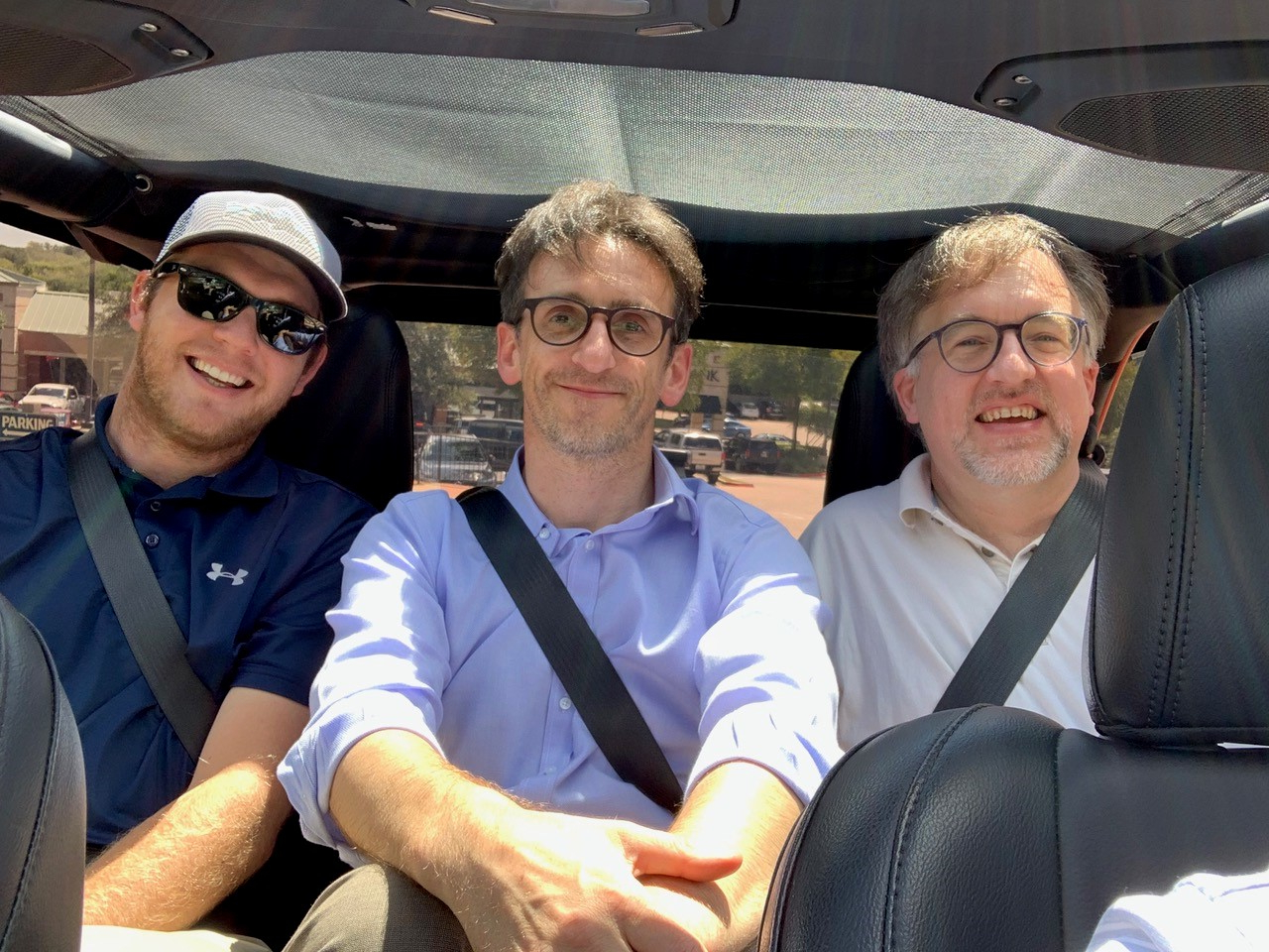 3 men in back of car.